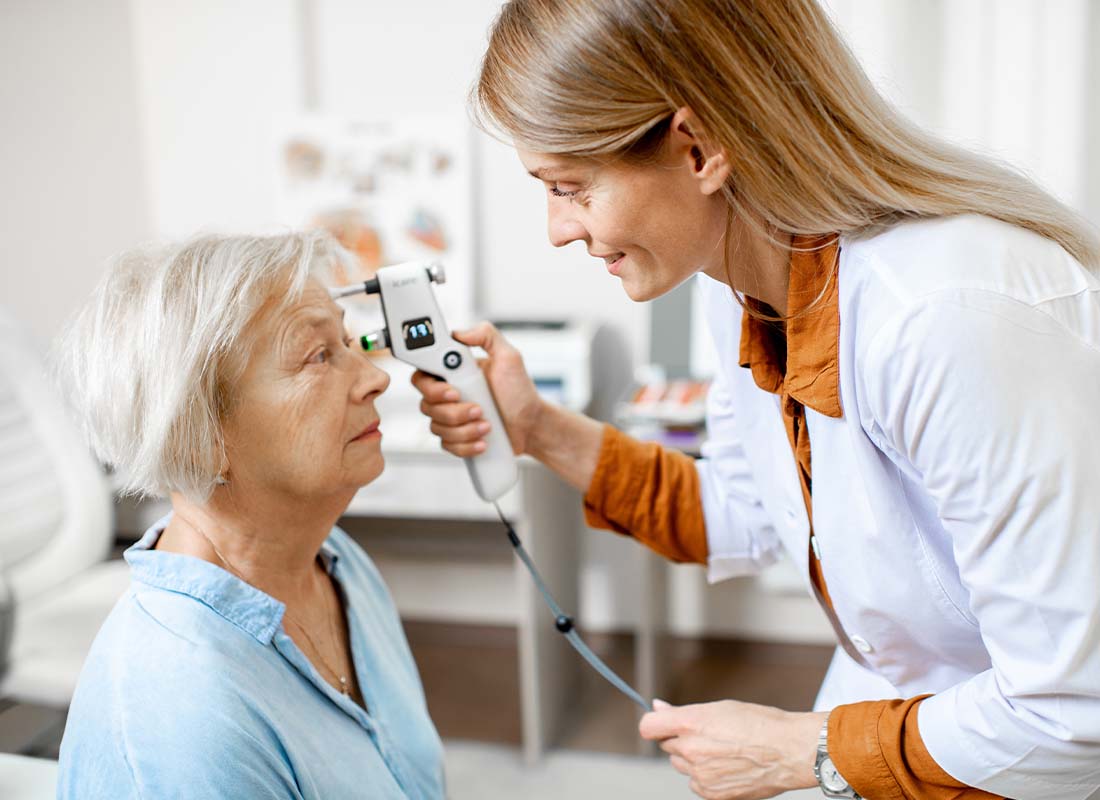 Dental, Vision, and Hearing Plans - Female Ophthalmologist Measuring the Eye Pressure with Modern Tonometer of a Senior Patient in the Medical Office
