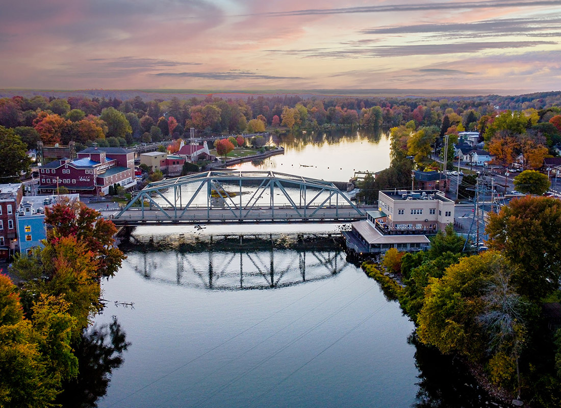 About Our Agency - Small town With Bridge Crossing a River